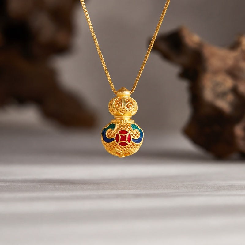 Gold-tone filigree gourd necklace suspended against a natural textured background