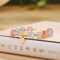 Gray moonstone and strawberry quartz bracelet on a warm book setting