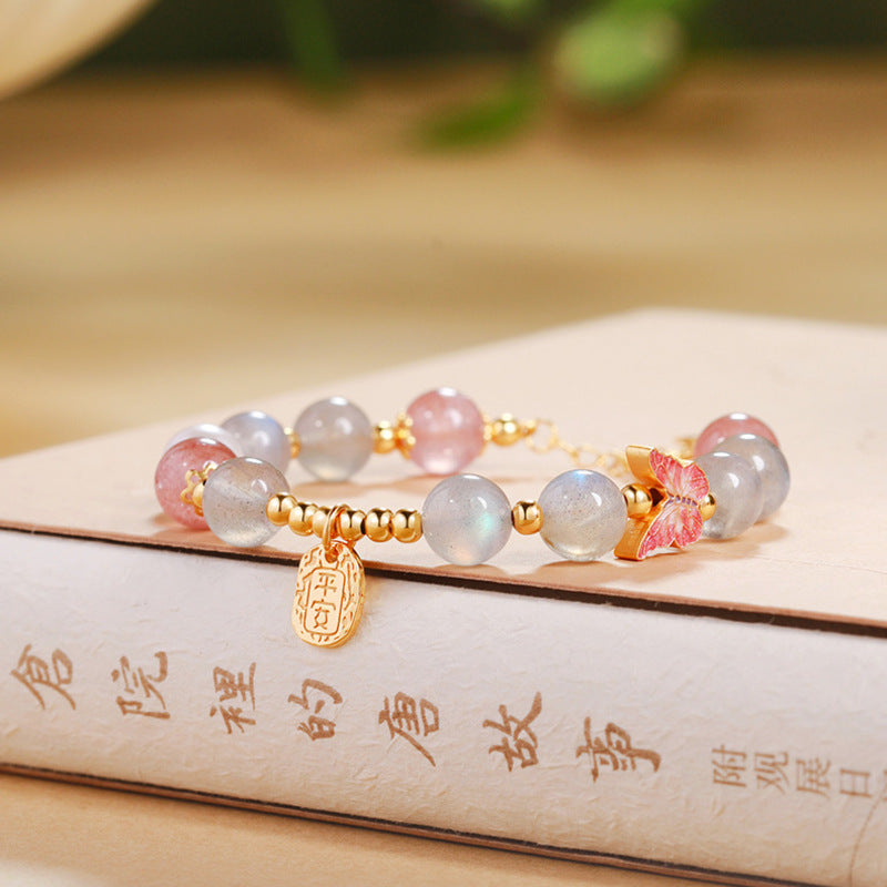 Gray moonstone and strawberry quartz bracelet on a warm book setting