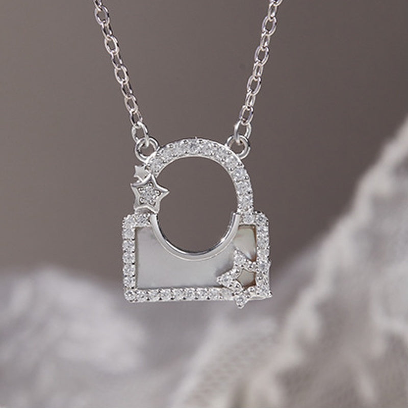 Silver star lock necklace suspended against taupe and lace