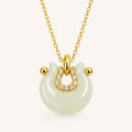 Hetian jade crescent peace lock necklace on ivory background