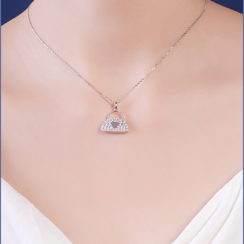 Heart handbag pendant necklace worn with a white neckline