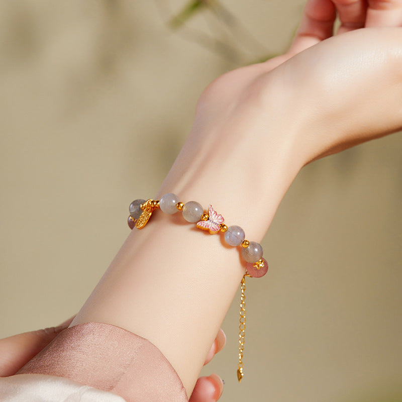 Gray moonstone bracelet worn on wrist with butterfly detail