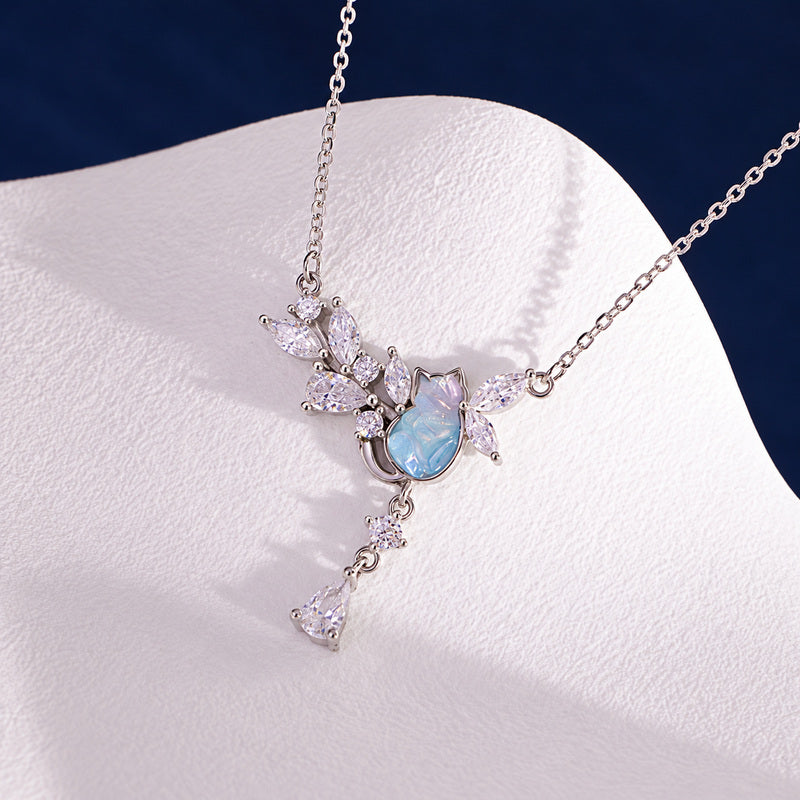Cat pendant necklace displayed on pale textured jewelry stand