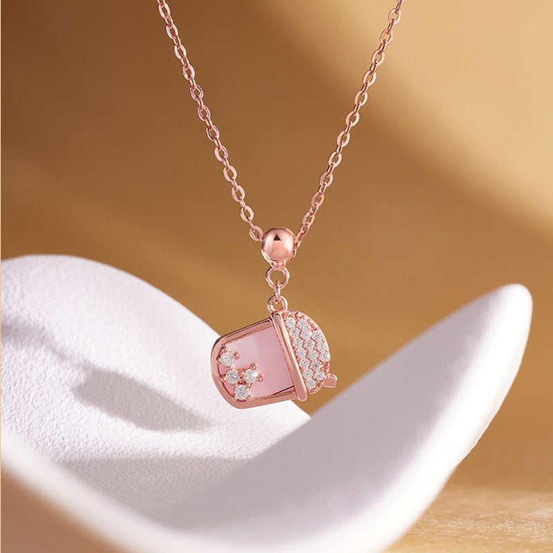 S925 silver milk tea cup necklace displayed on a white sculptural form