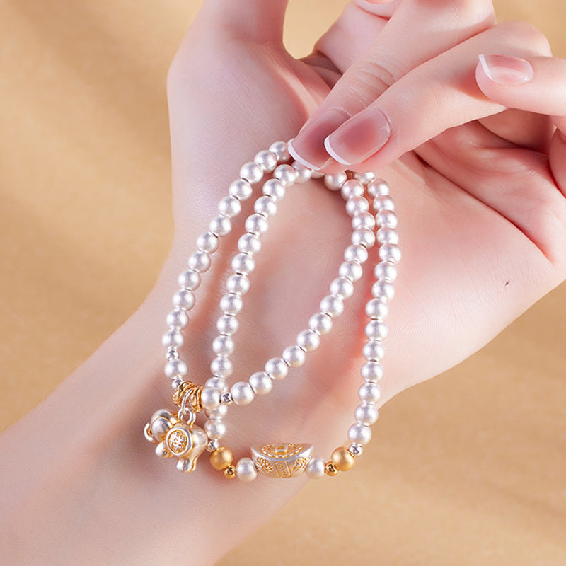 Model holding elephant charm double-wrap silver bracelet