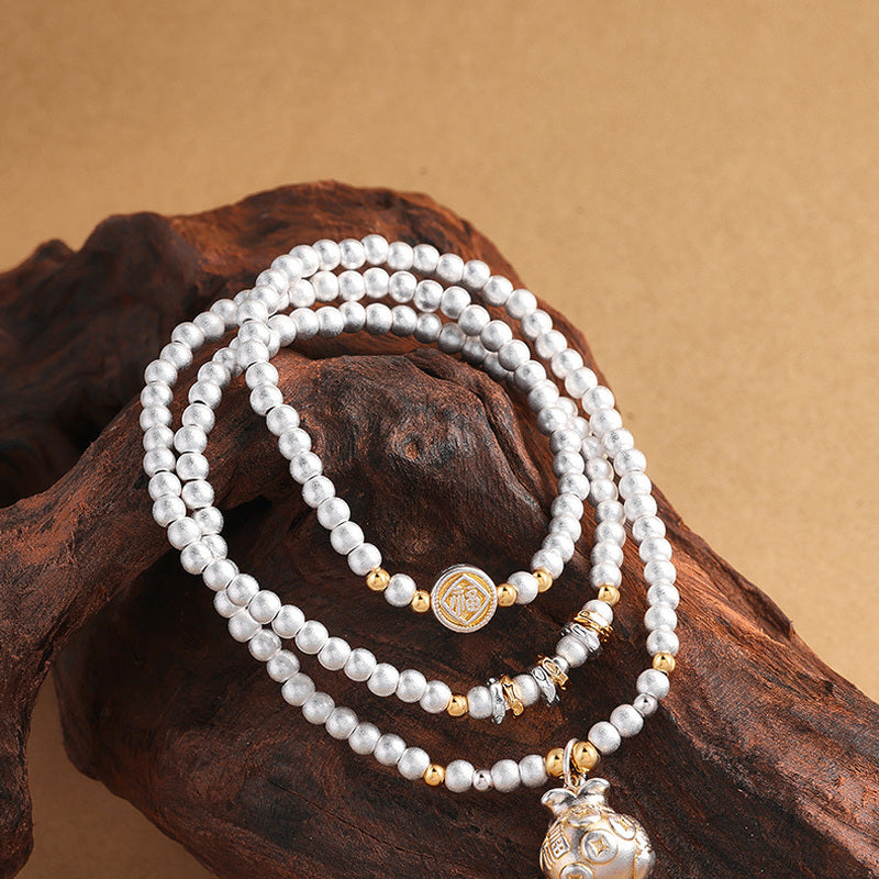 Multi-loop fine silver bracelet arranged on driftwood