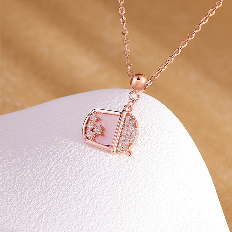 Close view of pink mother-of-pearl milk tea cup pendant and chain