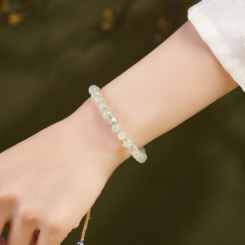 Pale green prehnite bracelet worn with a white sleeve