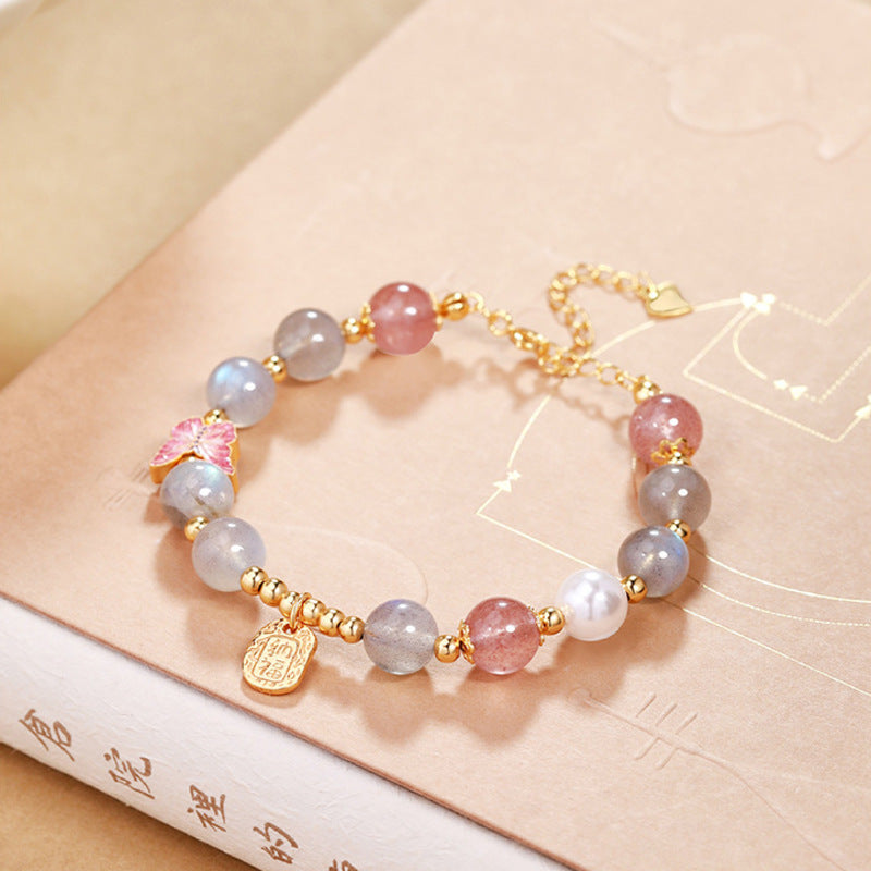 Angled view of gray moonstone bracelet with blessing plaque