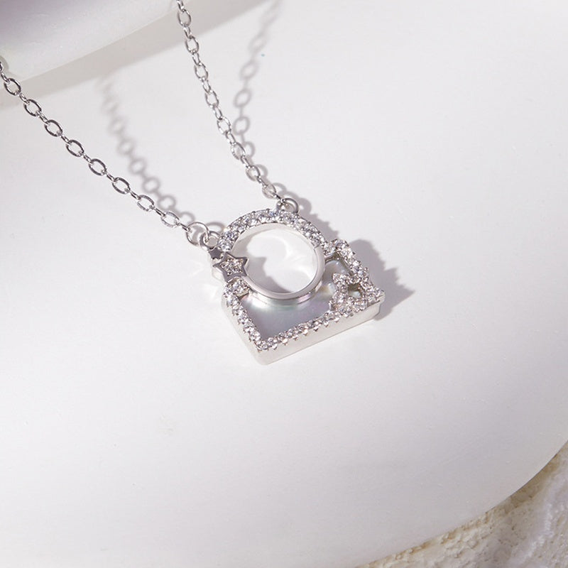 Star lock pendant on pale ceramic