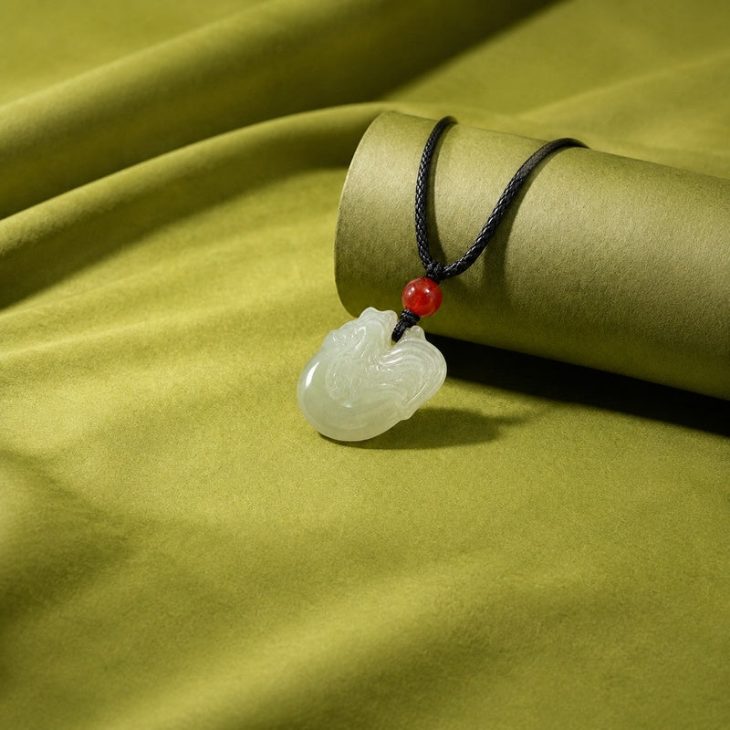 Angled view of carved nephrite jade rooster pendant