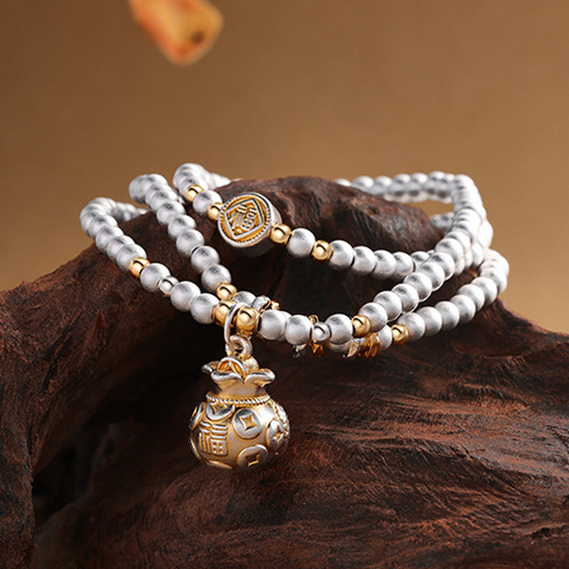 Silver bead and fortune pouch charm detail
