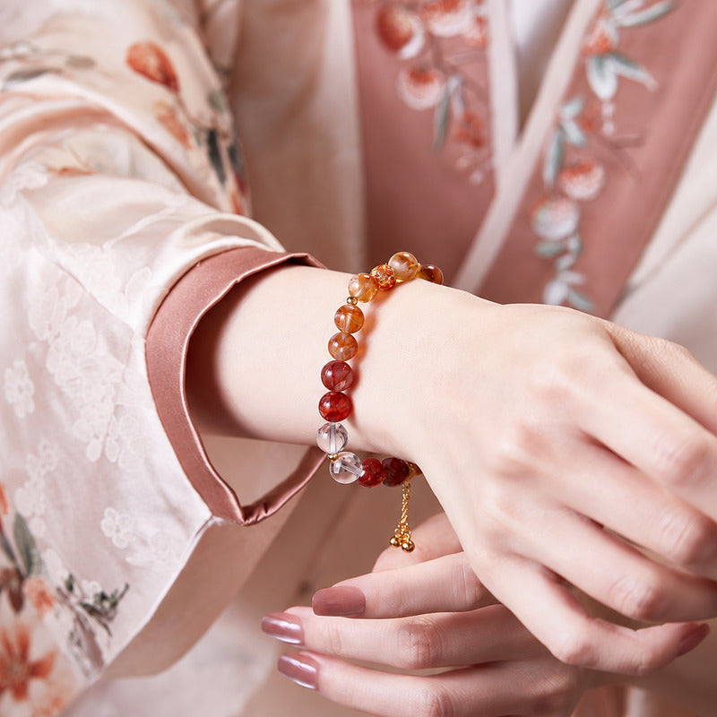 Red and golden crystal bracelet with tassel on model wrist