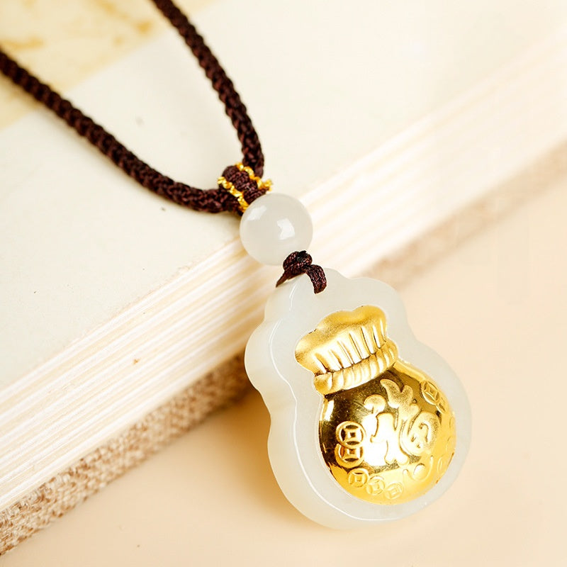 Nephrite jade fortune pouch pendant beside an ivory book
