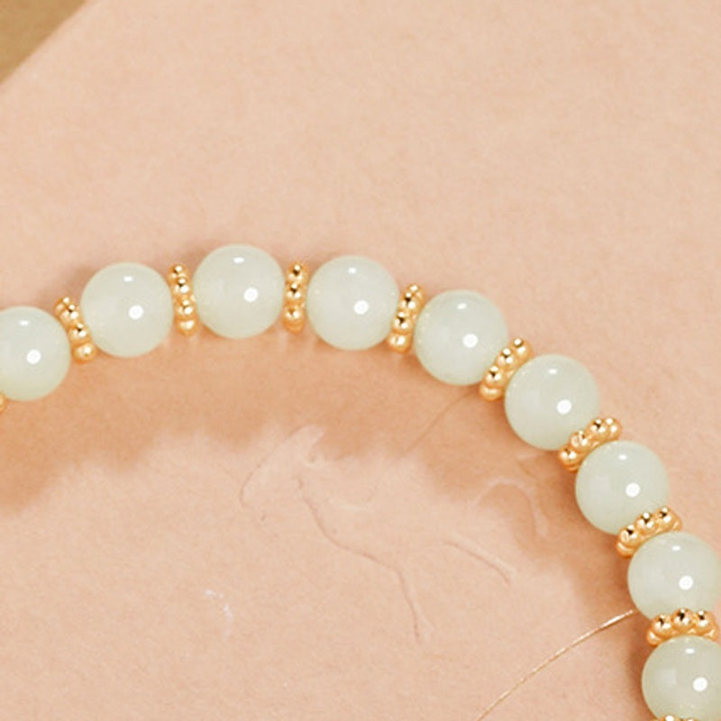 Polished pale nephrite jade round beads close-up
