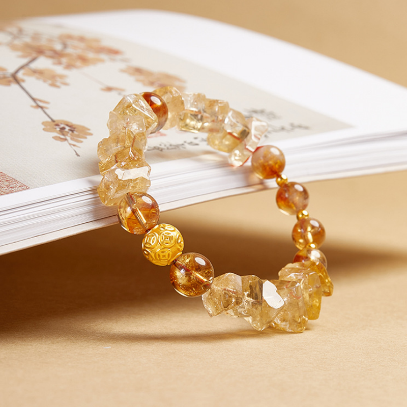 Original angled photograph of the silver coin bracelet against a book