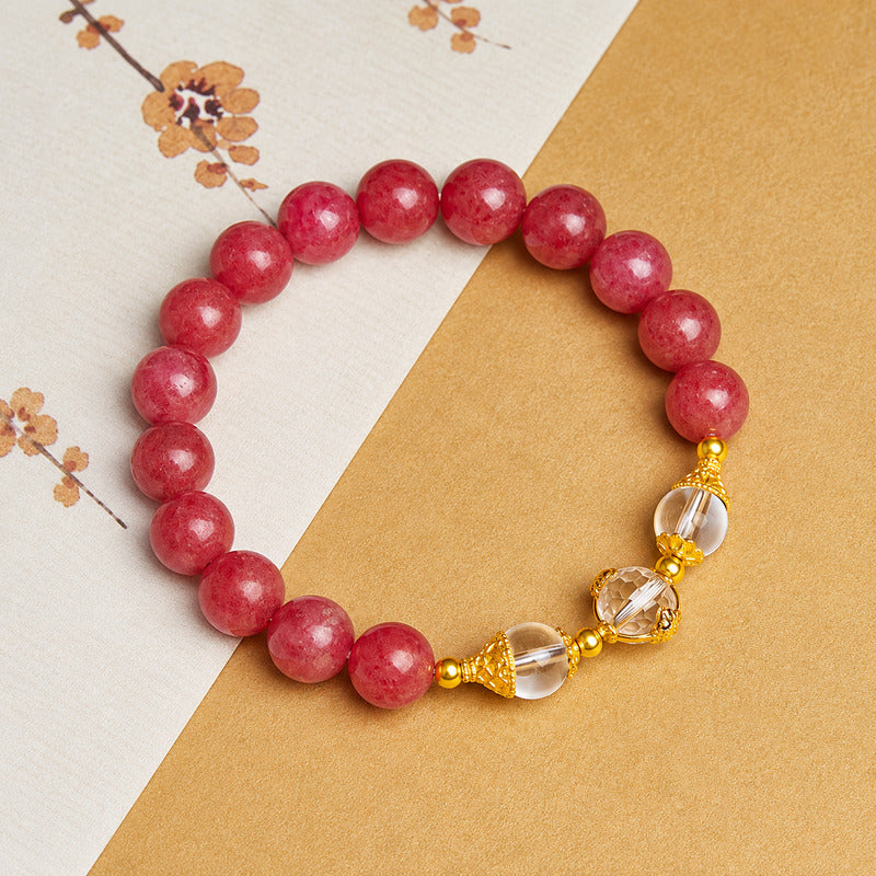 Angled view of rhodonite bracelet with clear quartz focal beads