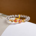 Red flower quartz and clear quartz bracelet on an open book