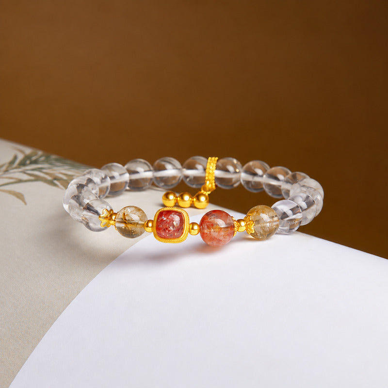 Red flower quartz and clear quartz bracelet on an open book