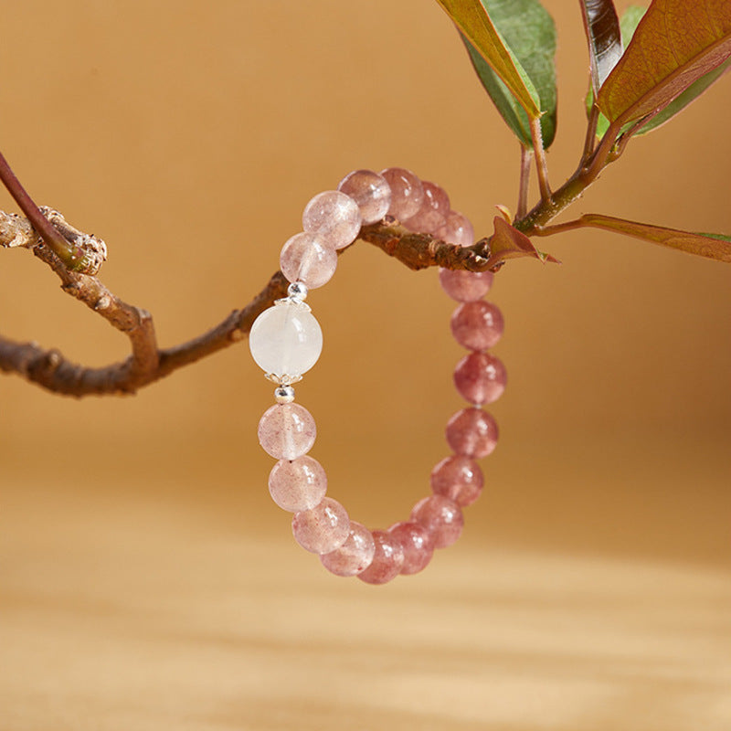 Single-loop strawberry crystal bracelet suspended from a branch