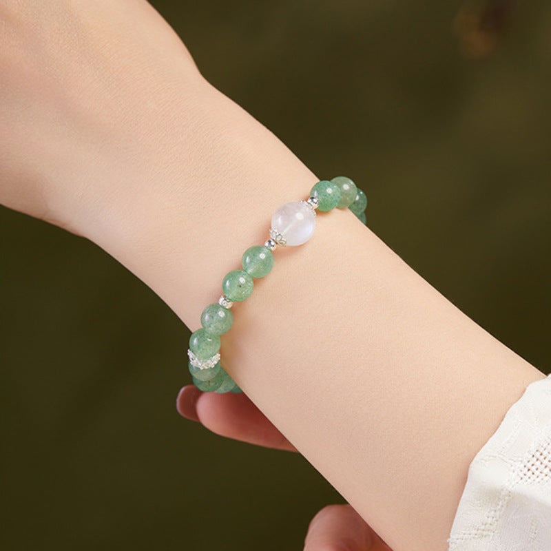 Green strawberry crystal bracelet with blue moonstone worn on the wrist