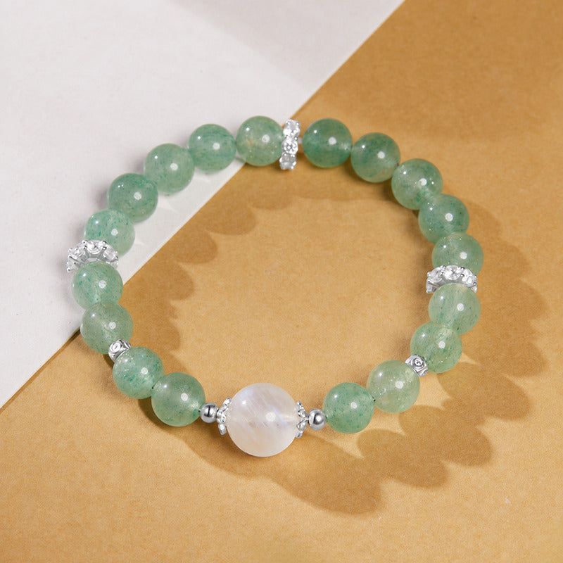 Overhead view of green strawberry crystal bracelet with a milky moonstone bead