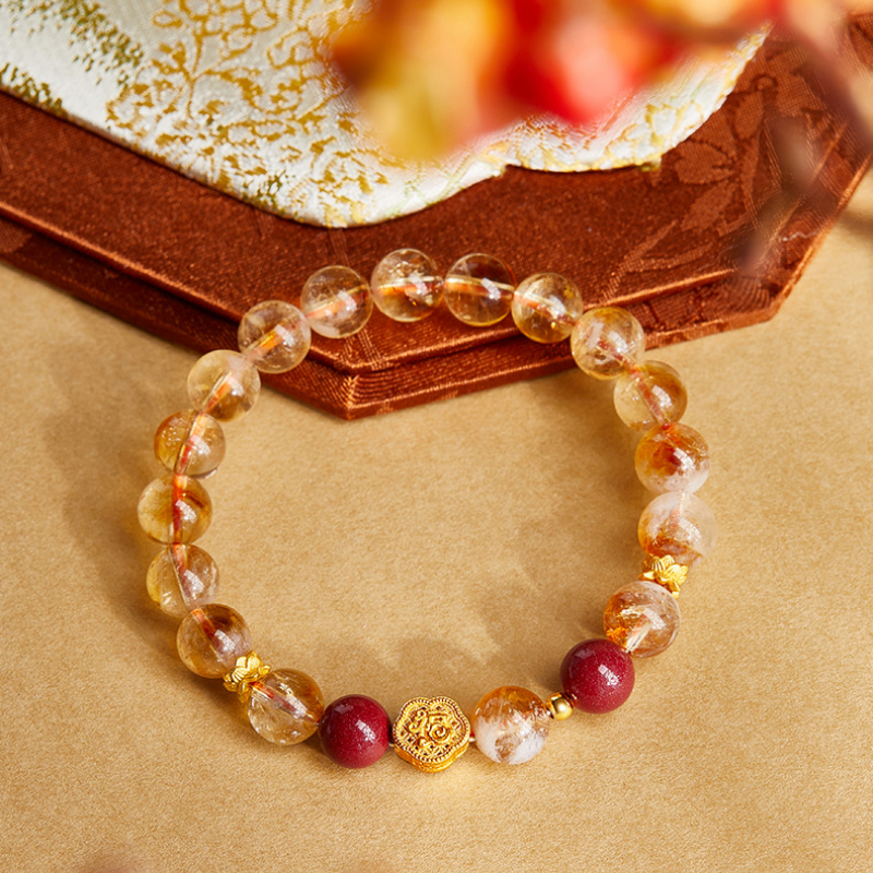 Overhead view of yellow quartz bracelet with deep red bead accents