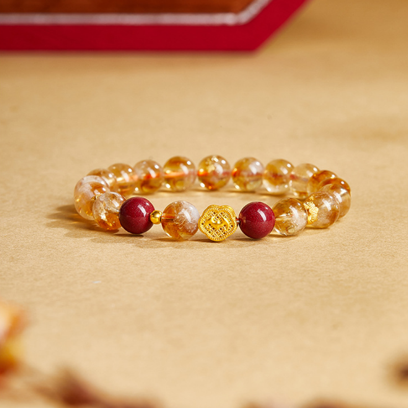 Yellow quartz good fortune bracelet with red beads on a warm golden background