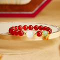 Red agate heart bracelet with jade and moonstone on a golden tray
