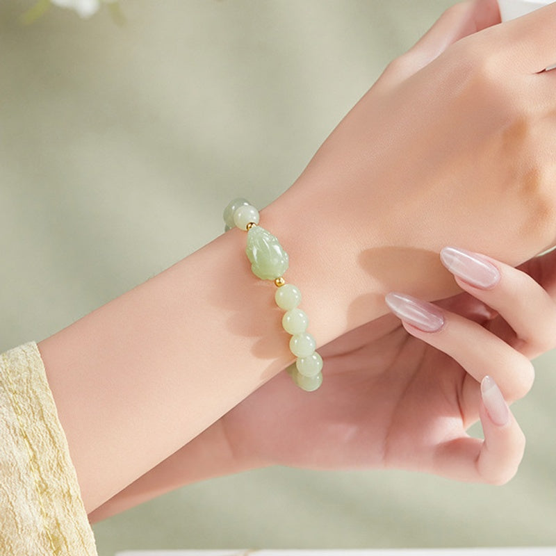 Nephrite jade toad bracelet worn with a cream sleeve