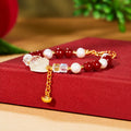 Lemon quartz Pixiu pearl bracelet with red agate and dangling ingot on red fabric