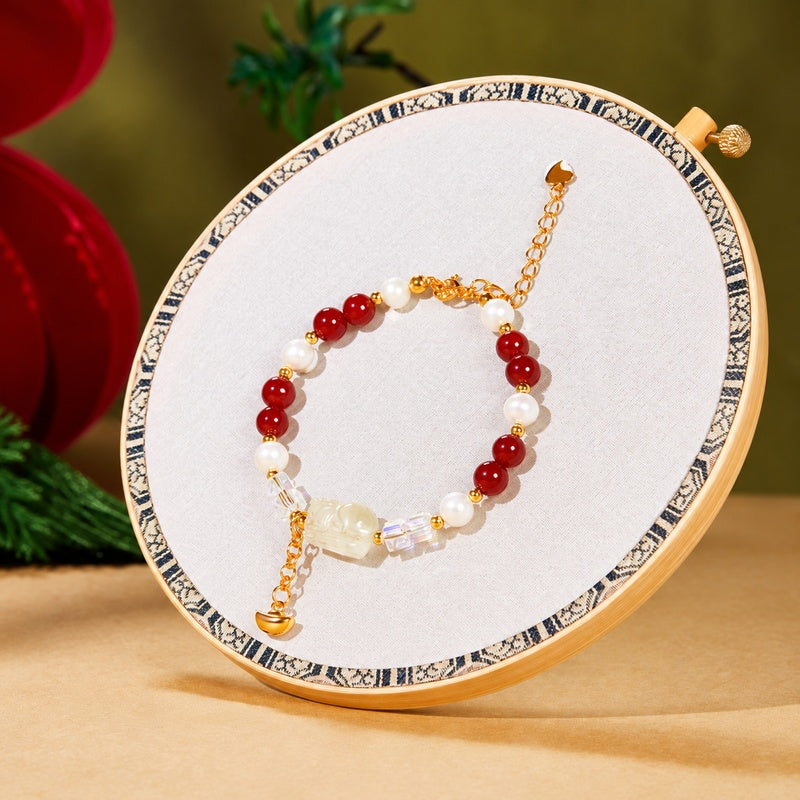 Pixiu pearl and red agate bracelet displayed on an embroidery hoop