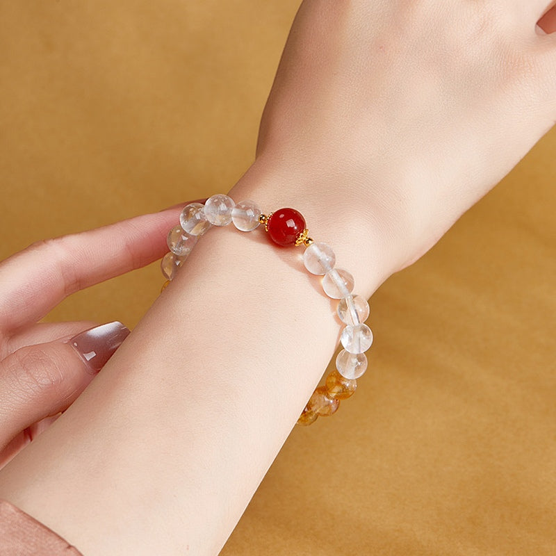 Close view of red agate and clear quartz beads on the wrist