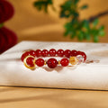 Red agate silver circle bracelet resting on a warm cream book