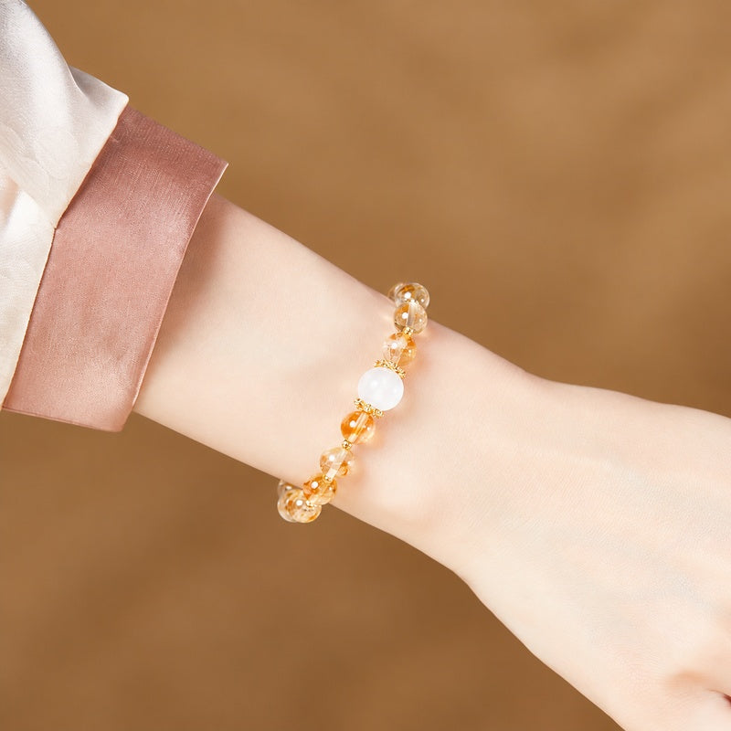 Yellow quartz and blue moonstone bracelet worn beside a satin cuff