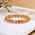 Yellow phantom quartz bracelet on a book in warm light