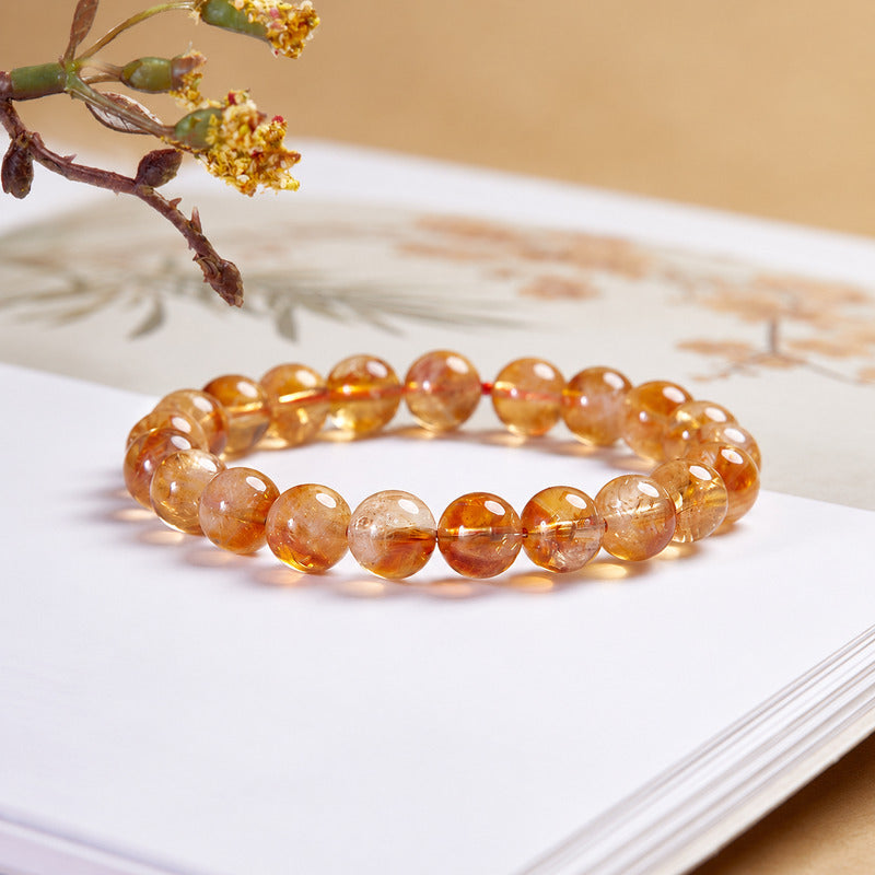 Yellow phantom quartz bracelet on a book in warm light
