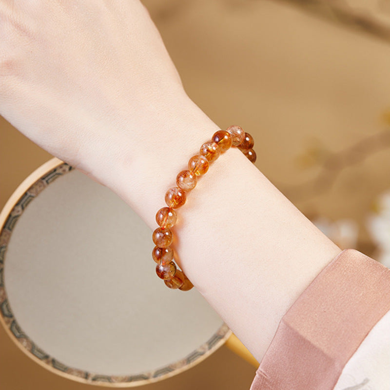 Yellow phantom quartz stretch bracelet worn beside a round mirror