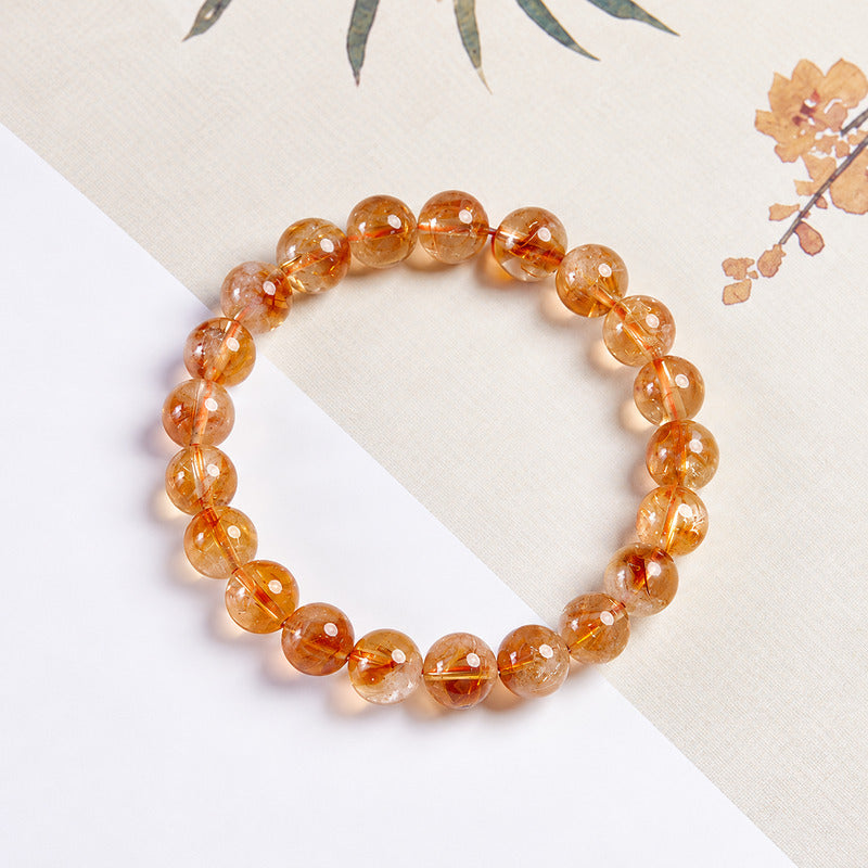 Golden yellow quartz bead bracelet viewed from above on a book