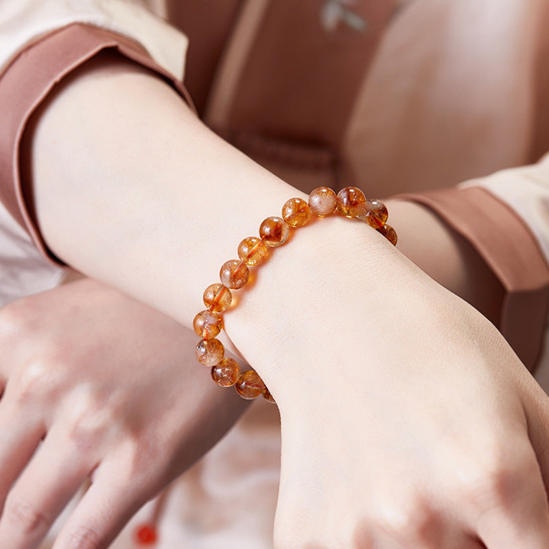 Yellow phantom quartz bracelet worn with a soft pink sleeve