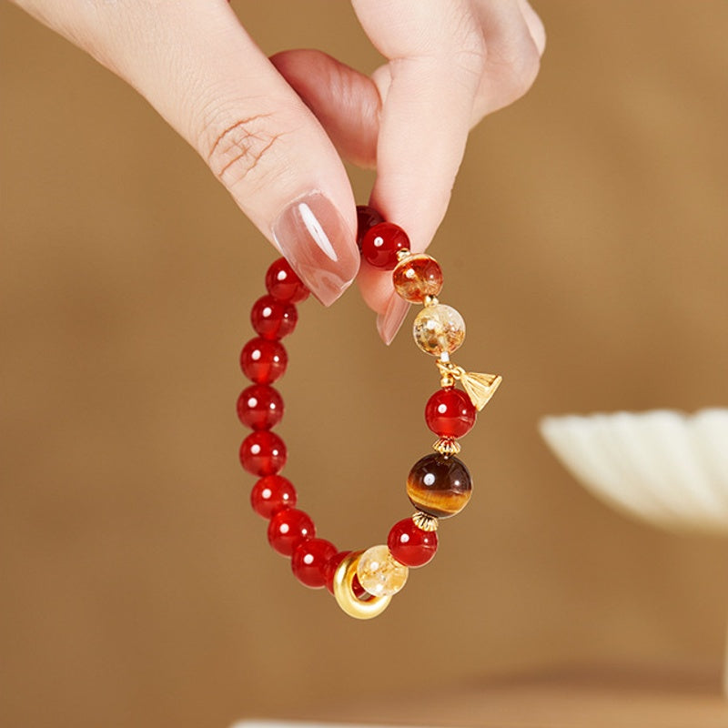 Red agate lotus seedpod bracelet held gently against a warm background