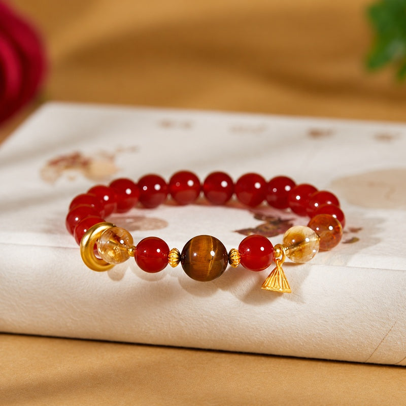 Front view of red agate and tiger eye bracelet with lotus charm