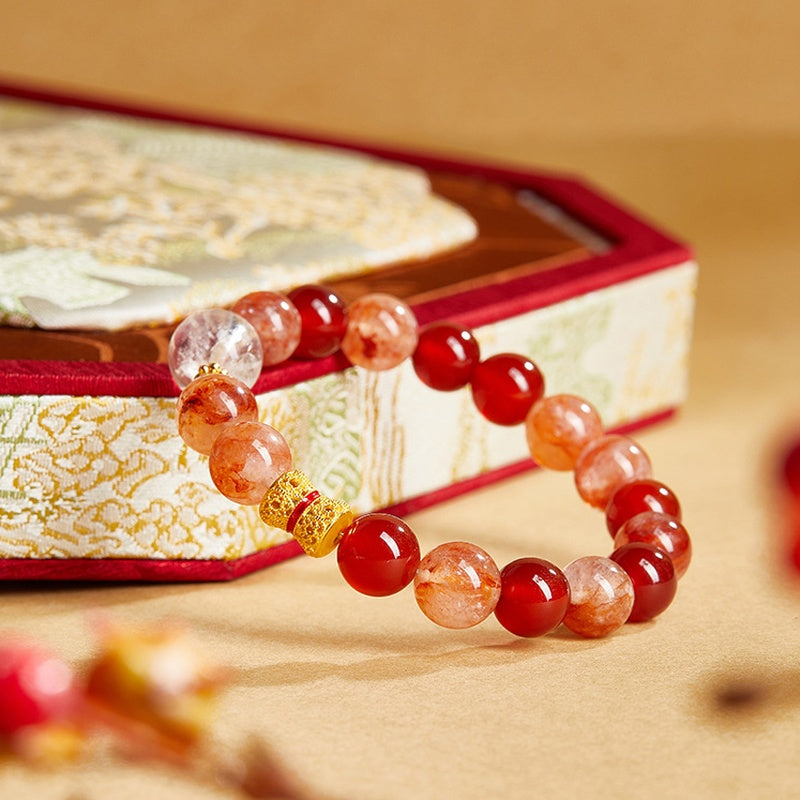 Red agate quartz bracelet resting beside a brocade box