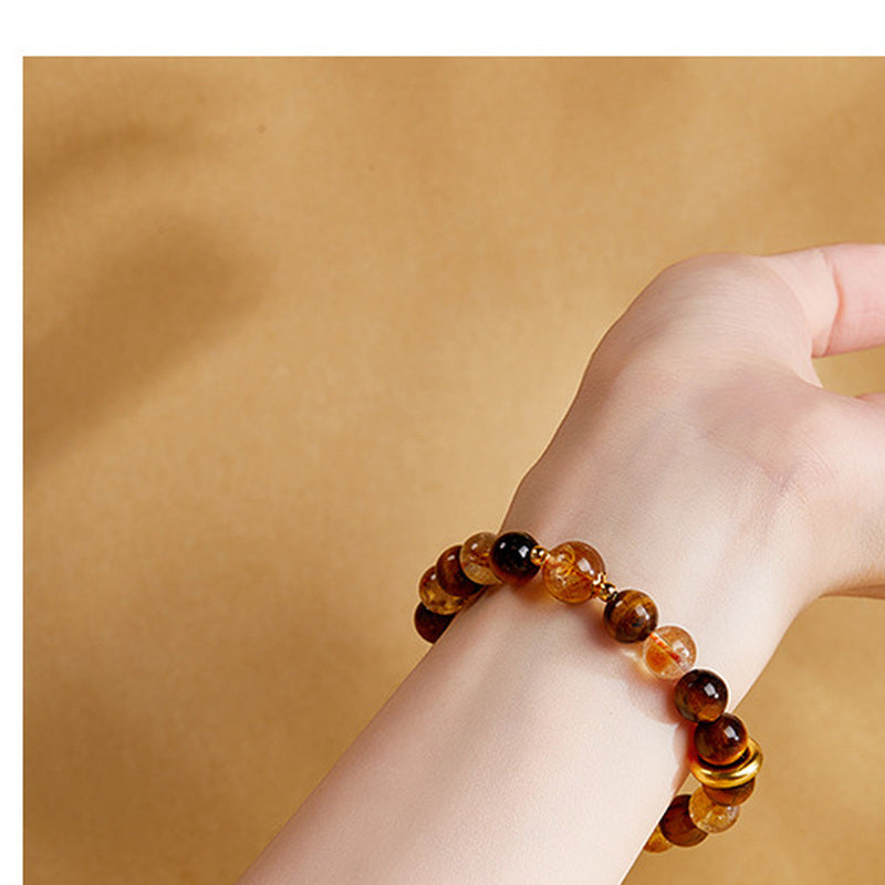 Yellow quartz and tiger's eye bracelet worn on a woman's wrist