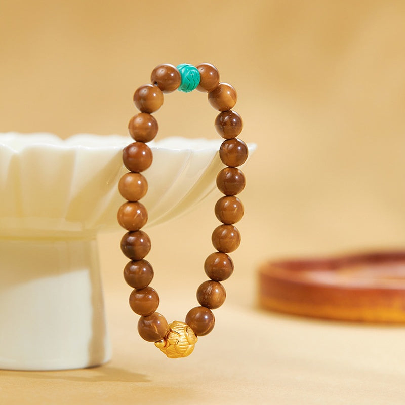 Kuka bracelet with synthetic turquoise and lotus bead beside a ceramic dish