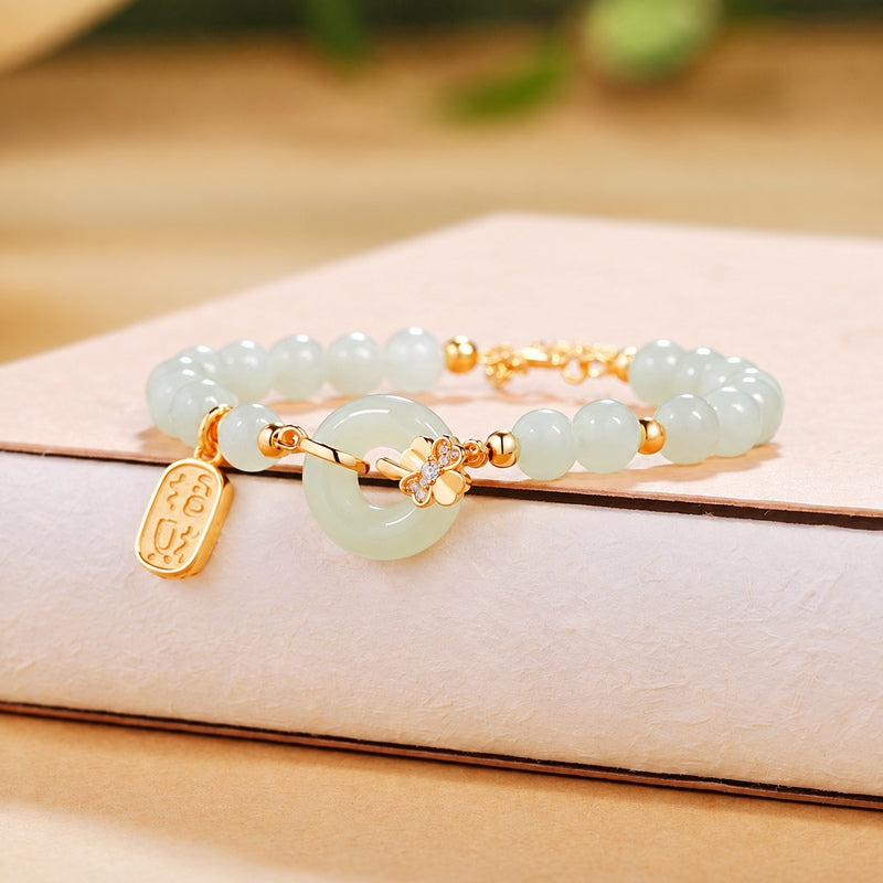 Nephrite jade peace roundel bracelet resting on a warm textured book