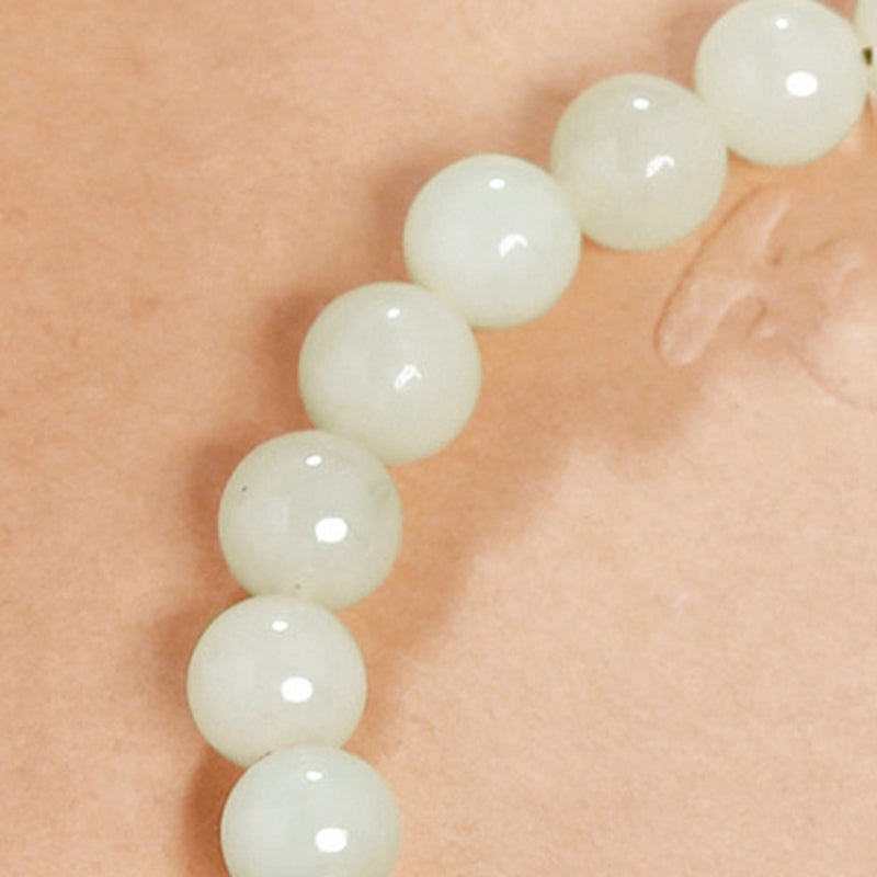 Pale green nephrite jade round beads showing smooth polished surfaces