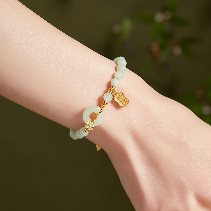 Nephrite jade peace roundel bracelet worn against a dark green background