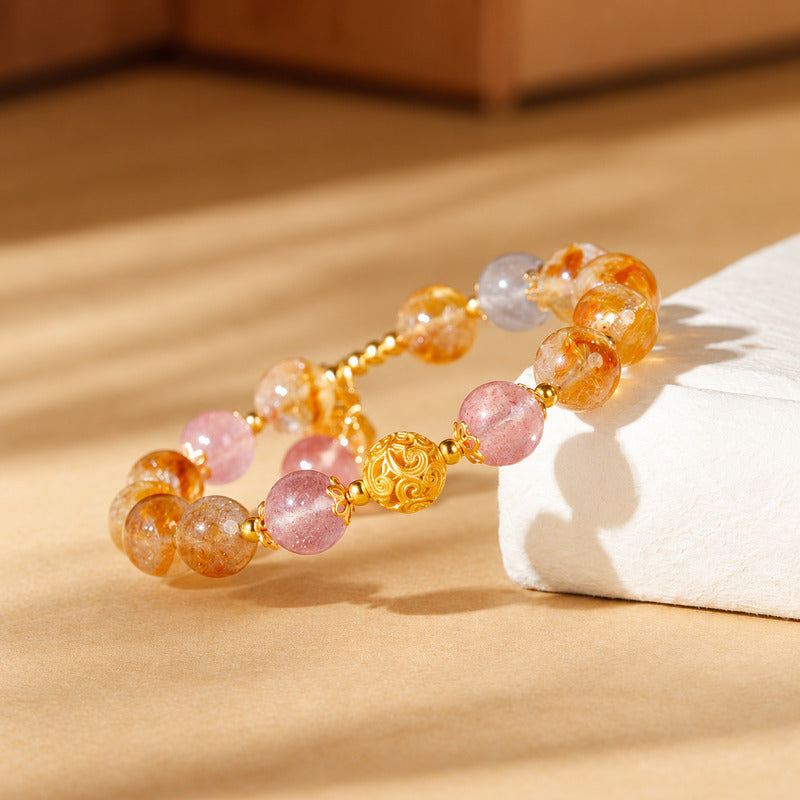Yellow tower quartz and strawberry quartz bracelet on warm sunlit paper
